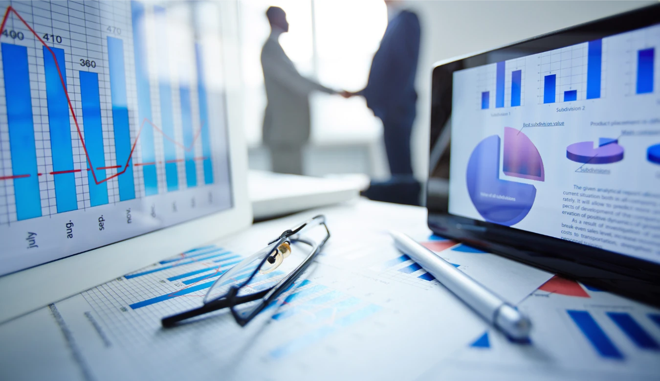 Picture of Sales charts on a computer screen with men shaking hands - Creative Pot Media