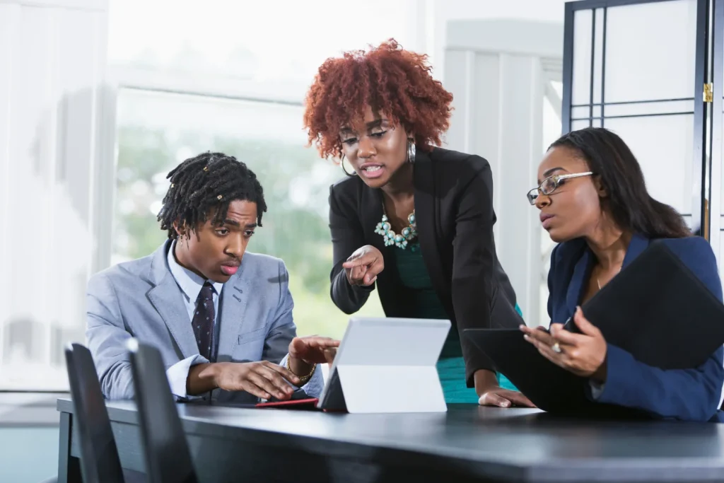 three young people looking at the laptop in the office