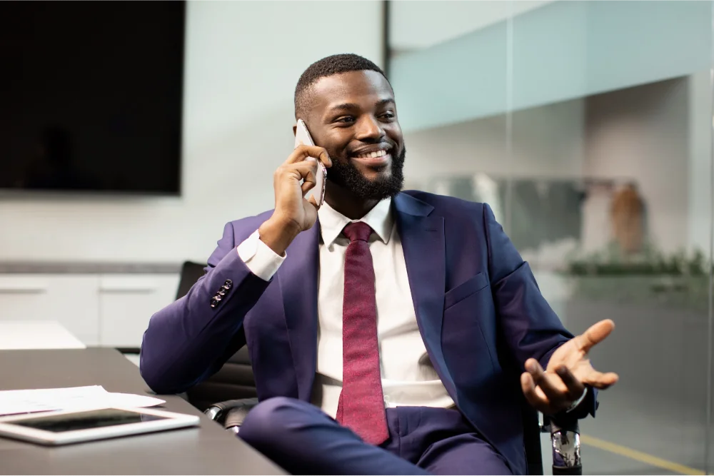 A man sitting on the chair talking to a through a cellphone